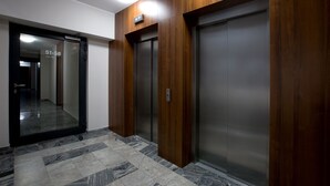 An elevator area with wooden paneling and a tiled floor. - Super-Apartamenty - Andersia VIP (Poznan)