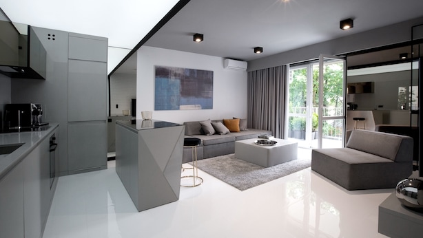 A modern kitchen with a central island, a dining area with a sofa and coffee table, and a large window with curtains. - Super-Apartamenty - Andersia VIP (Poznan)