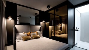 A modern bedroom with a large bed, a wardrobe, and a mirror. - Super-Apartamenty - Andersia VIP (Poznan)