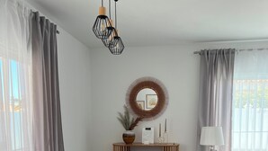 Ett modernt matområde med ett glasbord, grå stolar och ett trägolv.