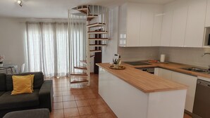 Una cocina moderna con armarios blancos, una encimera de madera y un lavavajillas integrado.