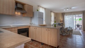 Una cocina moderna con armarios de madera, horno integrado y refrigerador.