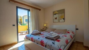 Une chambre à coucher avec un lit, une table de chevet, une lampe et un tableau au mur.