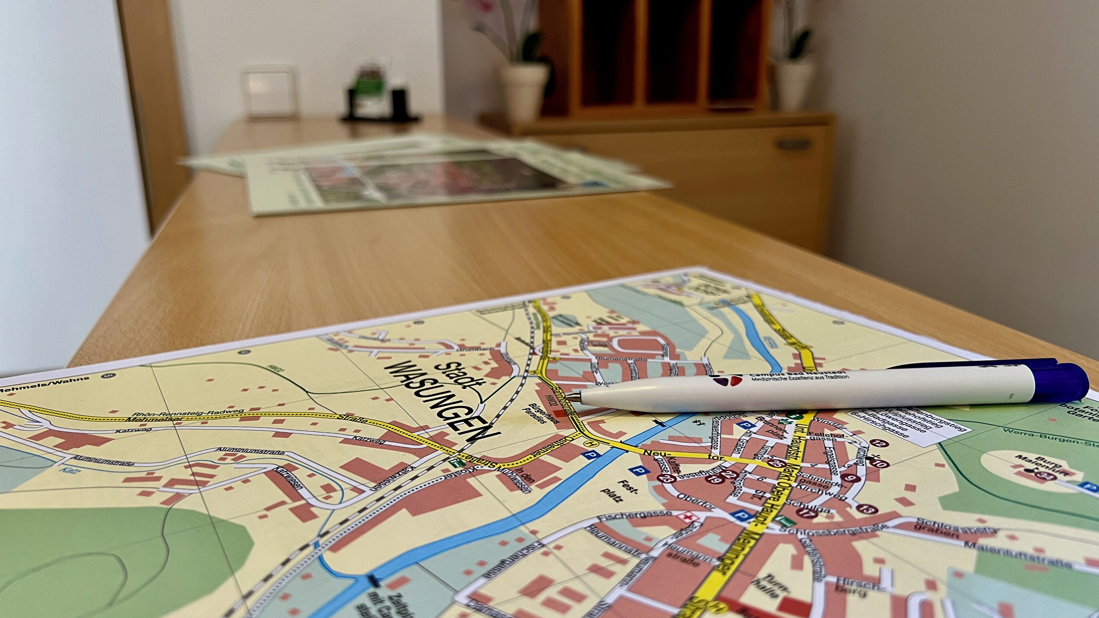 A map of Wasington on a wooden table with a pen.