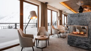 Un moderno vestíbulo de hotel con ventanas amplias, asientos cómodos y una chimenea.