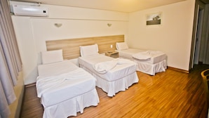 A hotel room with two beds, a wooden headboard, a small bedside table with a lamp, and a picture on the wall. - Dallé Hotel (Bage)
