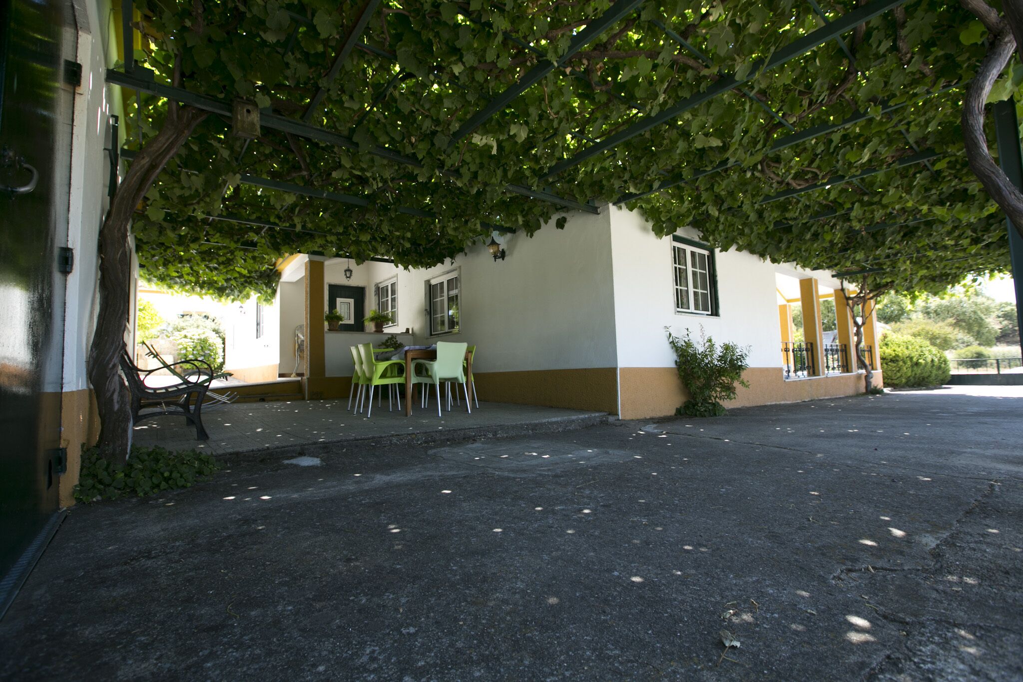 A building with a covered outdoor seating area, a door, and a window.