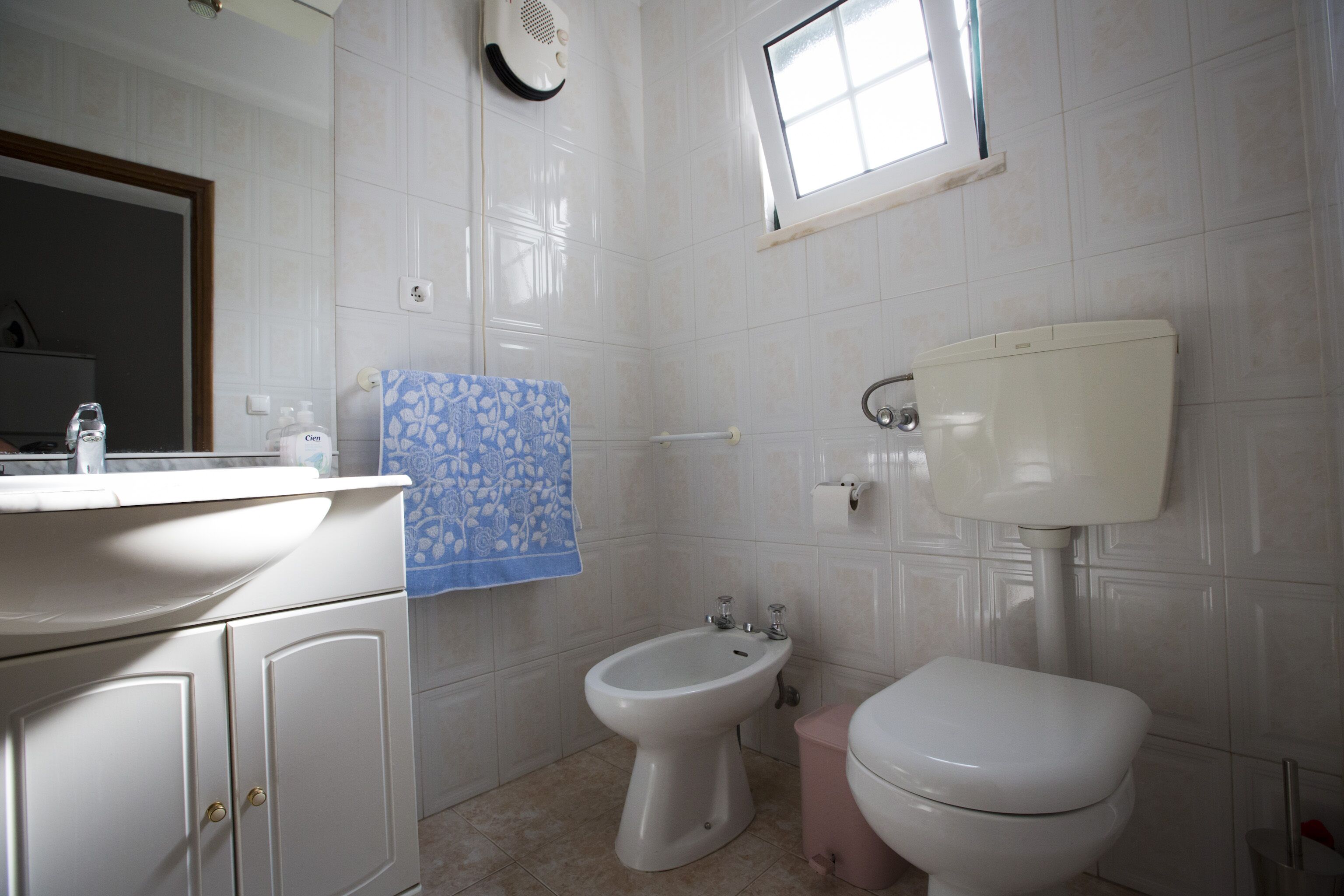 Et badeværelse med toilet, bidet og håndvask.