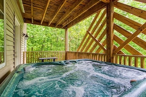 A hot tub with a wooden deck and a view of lush greenery. - 3 King Suites/Hot Tub/Game Room/Walk to Ober/5 Minutes to Downtown Gatlinburg (Gatlinburg)