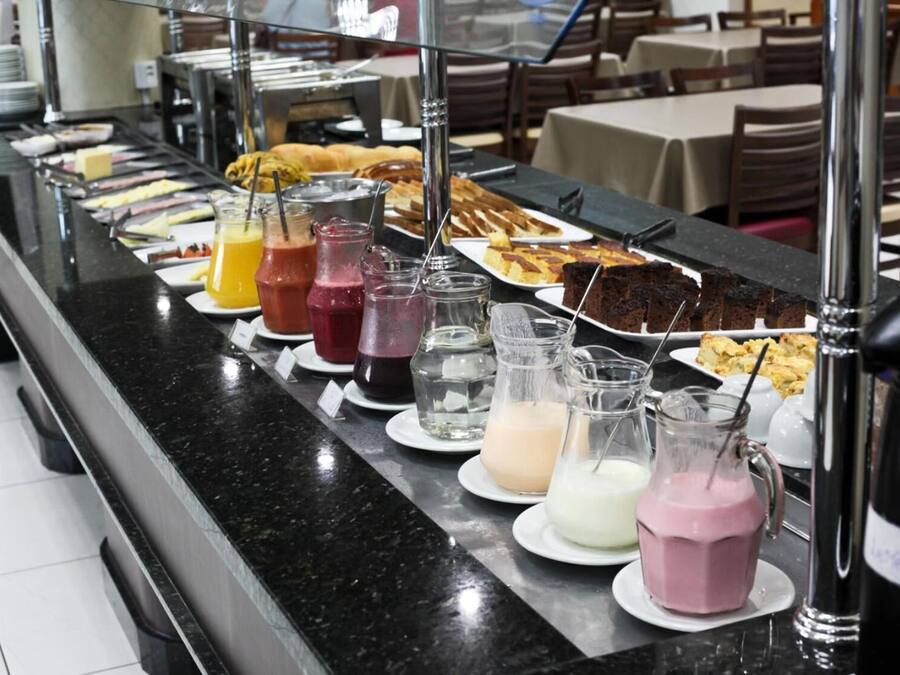 A buffet counter with various food items and beverages.