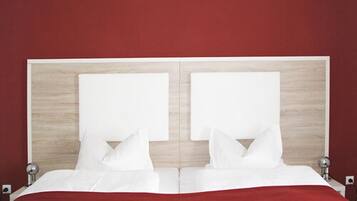 Una cama doble con cabecera de madera y ropa de cama blanca.