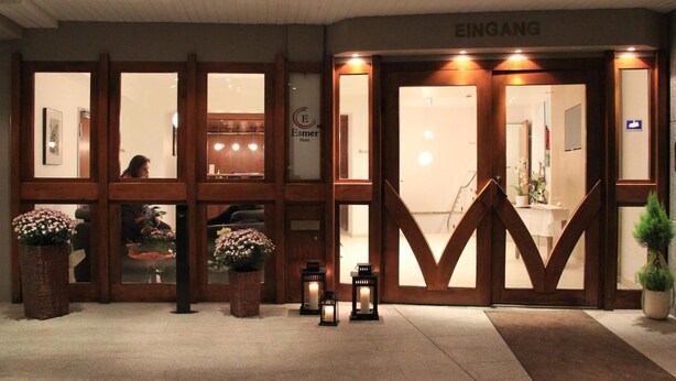 A hotel entrance with wooden doors, a reception desk, and a sign for 'EINGANG'. - Stadthotel Alsfeld (Alsfeld)