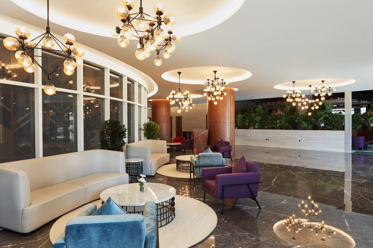 A modern lobby with a curved seating area, multiple light fixtures, and a view of the outdoor area.