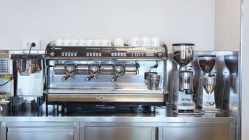 Máquina de espresso La Cimbali con múltiples dosificadores de café y un molinillo.