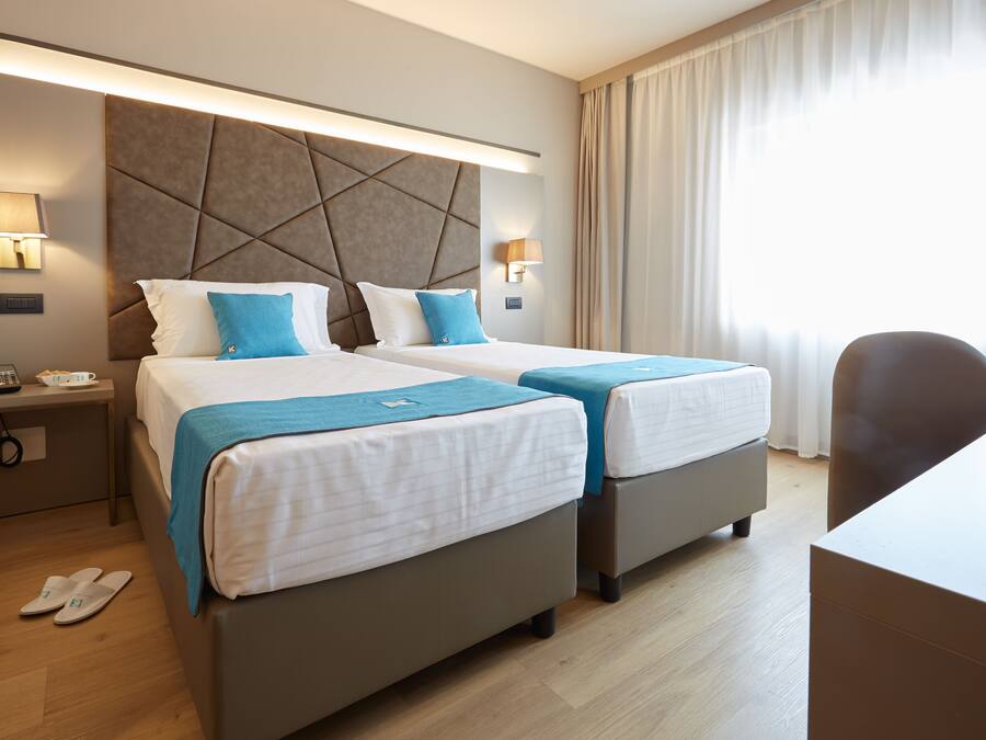 Una habitación de hotel con dos camas, un escritorio y una silla.