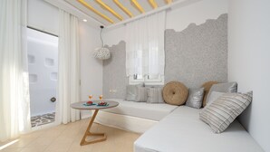 A modern room with a sofa, a round table, and a decorative wall. - My Island Home (Naxos)