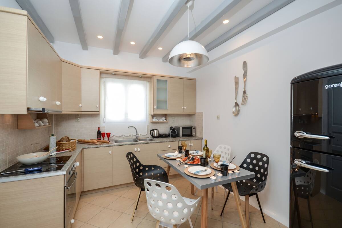 Une cuisine moderne avec un coin repas, comprenant une cuisinière, un four à micro-ondes et une table à manger pour quatre personnes.