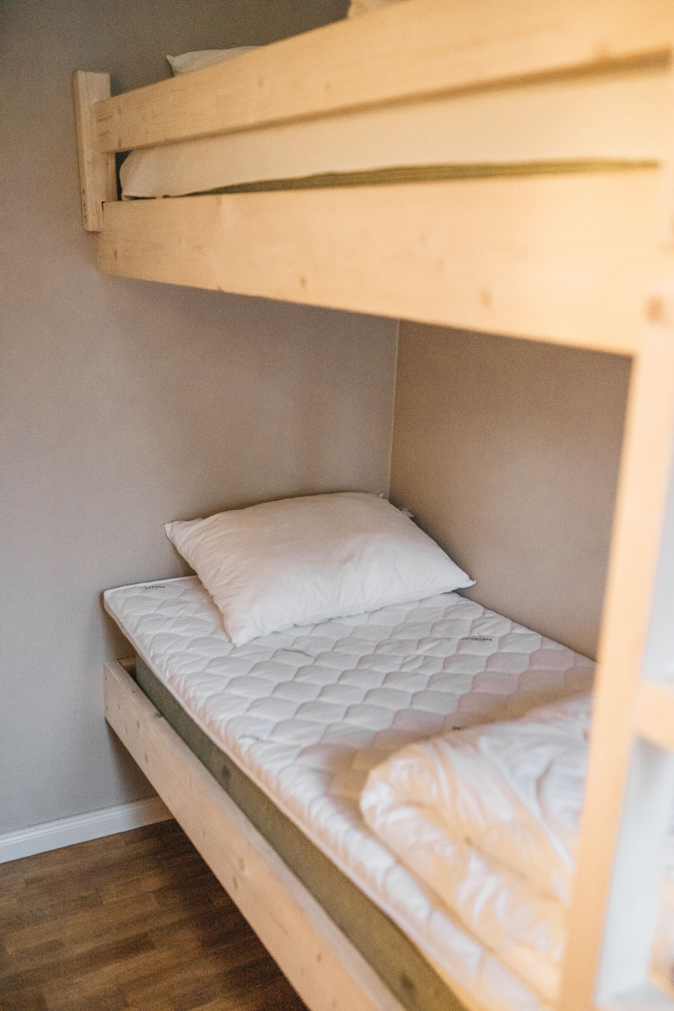 Una cama litera con colchón y almohadas.