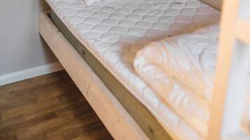 Una cama litera con colchón y almohadas.