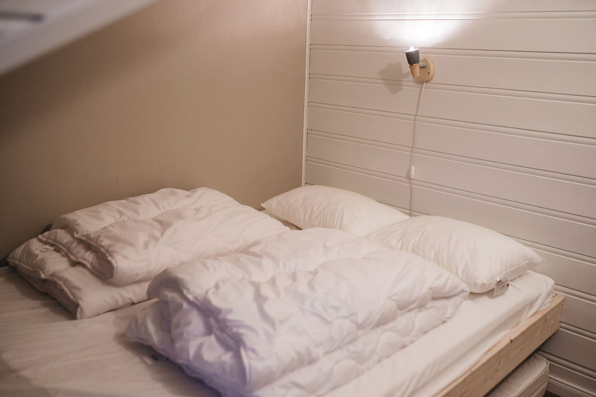 A single bed with white bedding and a headboard with horizontal lines.