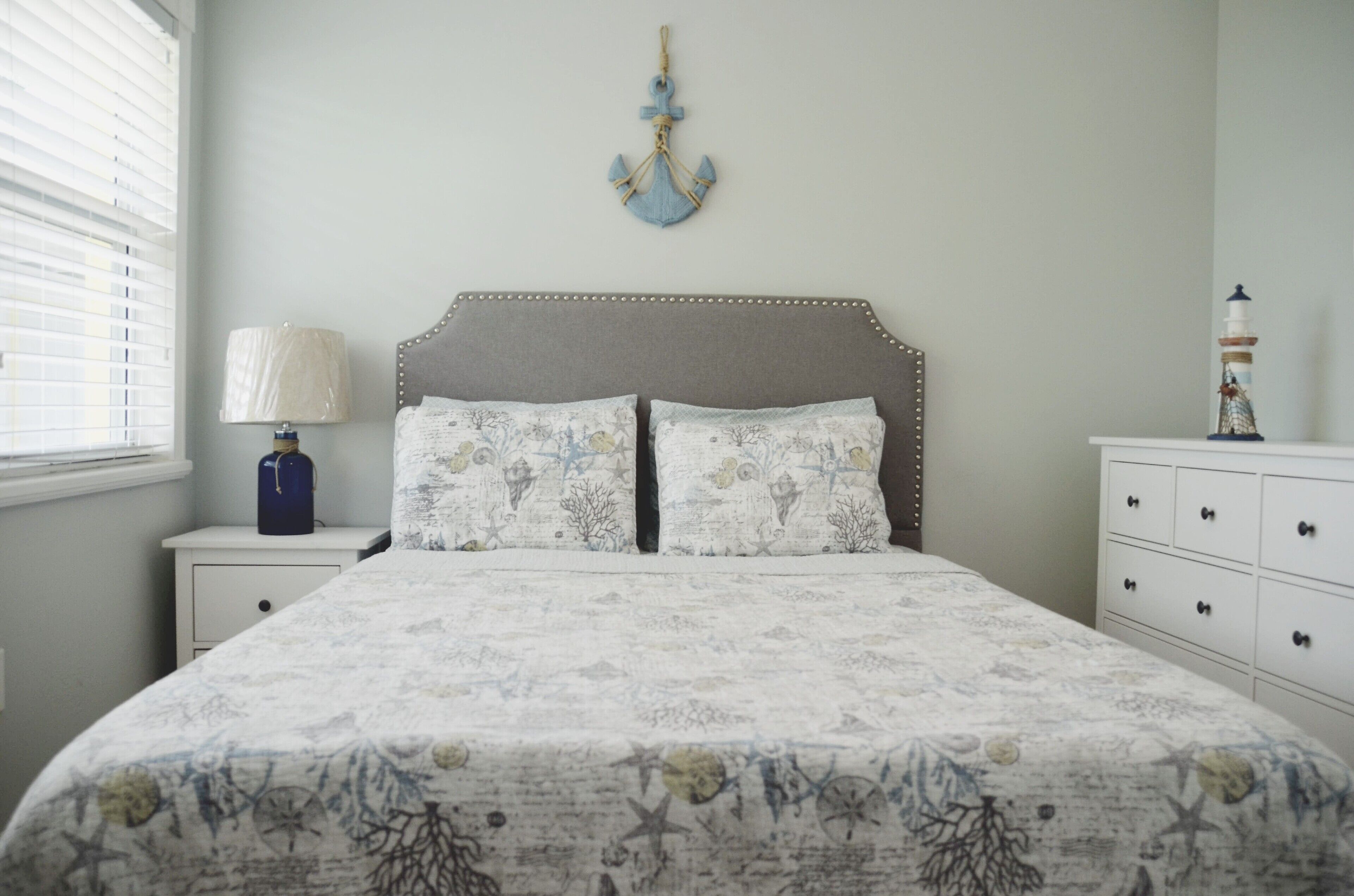 Une chambre à coucher avec un lit, des tables de chevet, une lampe et une commode.