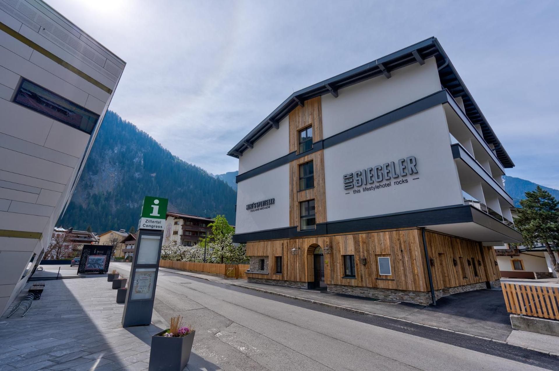 Un hotel moderno con fachada de madera y un cartel que indica Zillertal Congress.