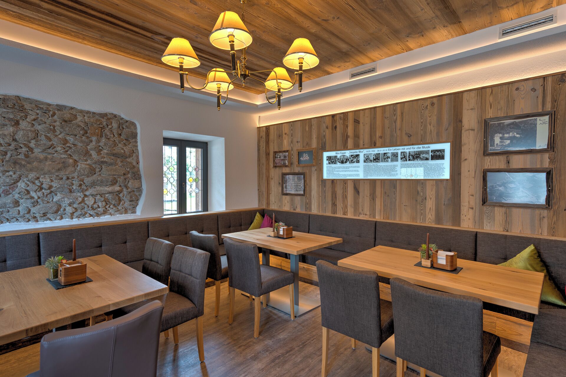 L’intérieur du restaurant est agrémenté de murs en bois, d’éléments décoratifs en pierre et propose différents types de sièges, notamment des banquettes et des tables.