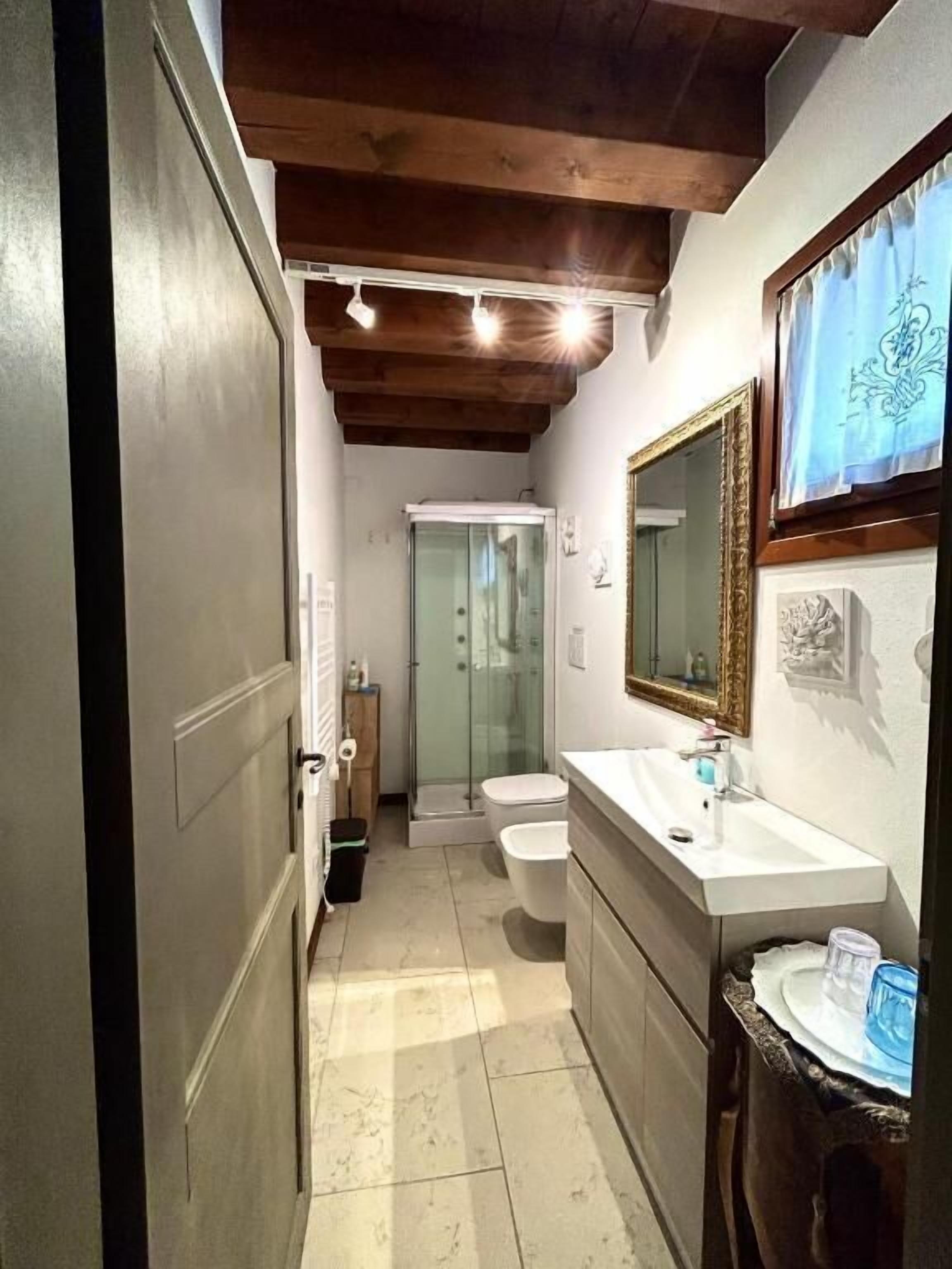 Een kleine badkamer met een douche, toilet en wastafel.
