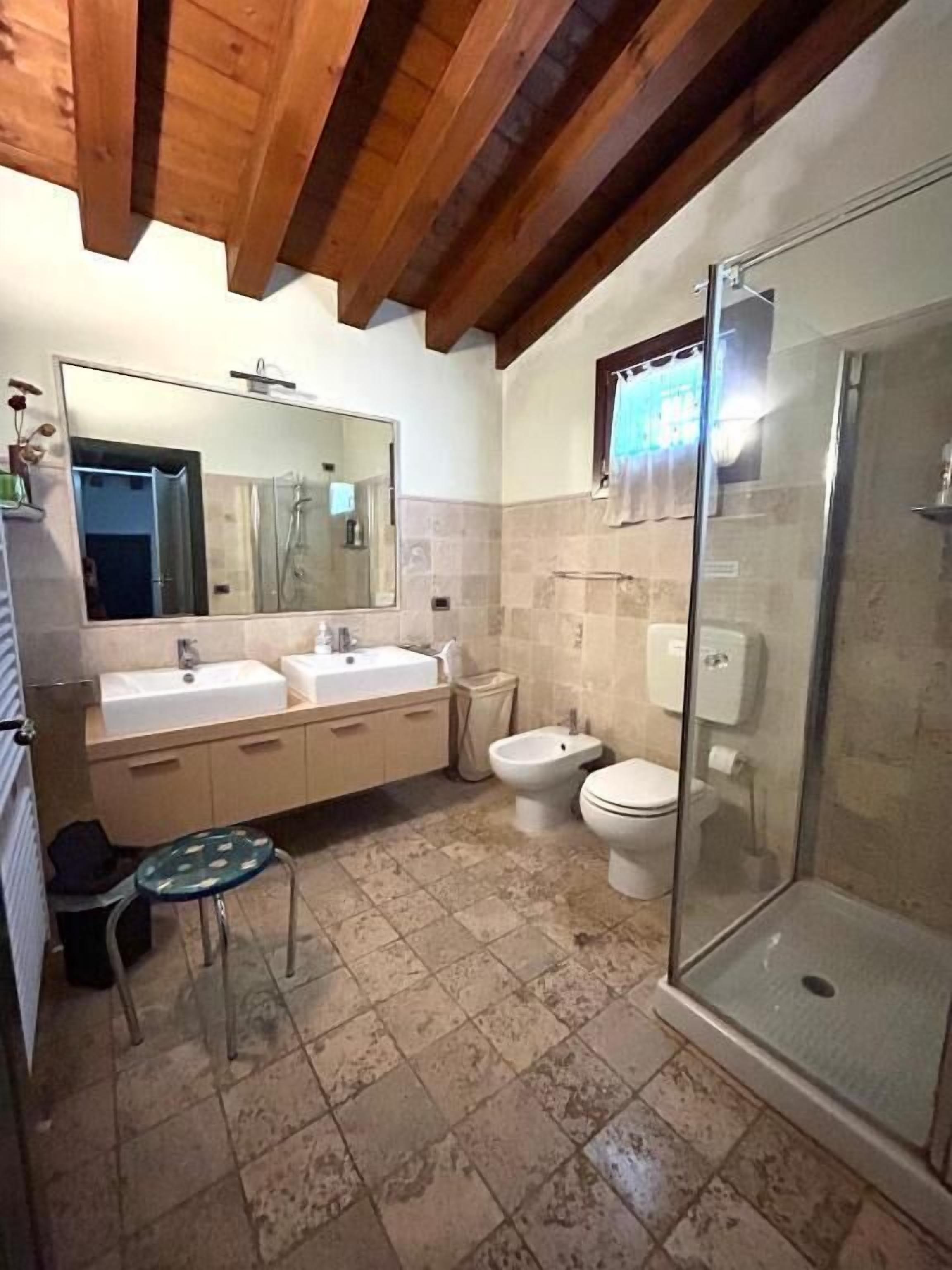 Une salle de bain avec douche, toilettes et lavabo.