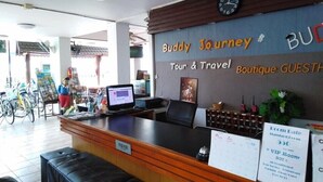 A reception desk with a computer, a clock, and a sign for a VIP room. - Buddy Guesthouse (Chiang Mai)