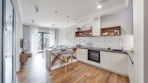 Una cocina moderna con una isla central, suelo de madera y electrodomésticos integrados.