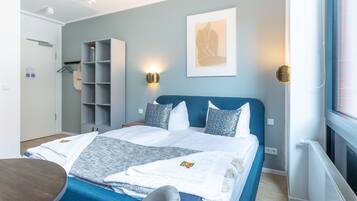 Un dormitorio moderno con cama, mesitas de noche, armario y ventana.