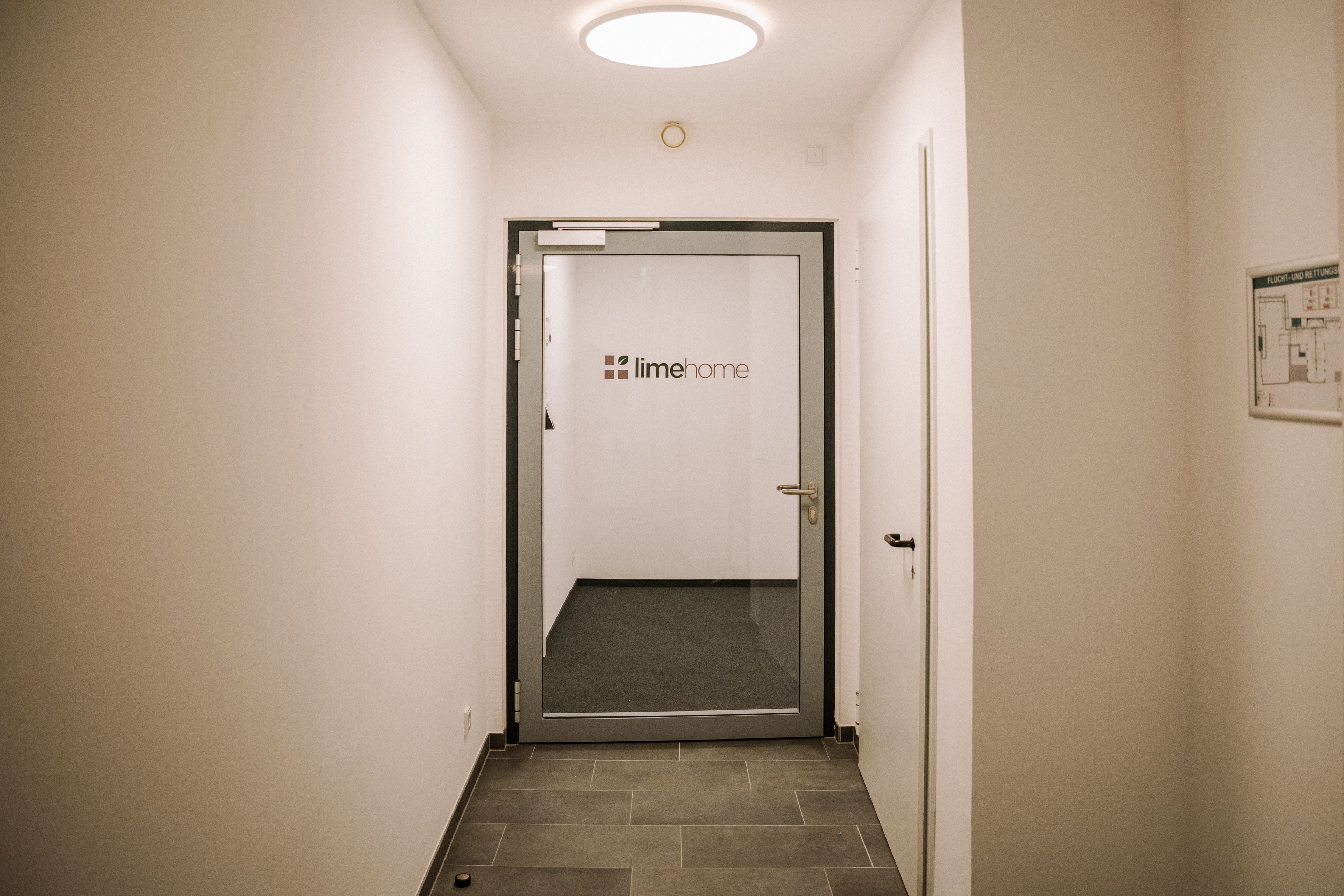 A hallway with a door labeled "limehome" leading to a room.