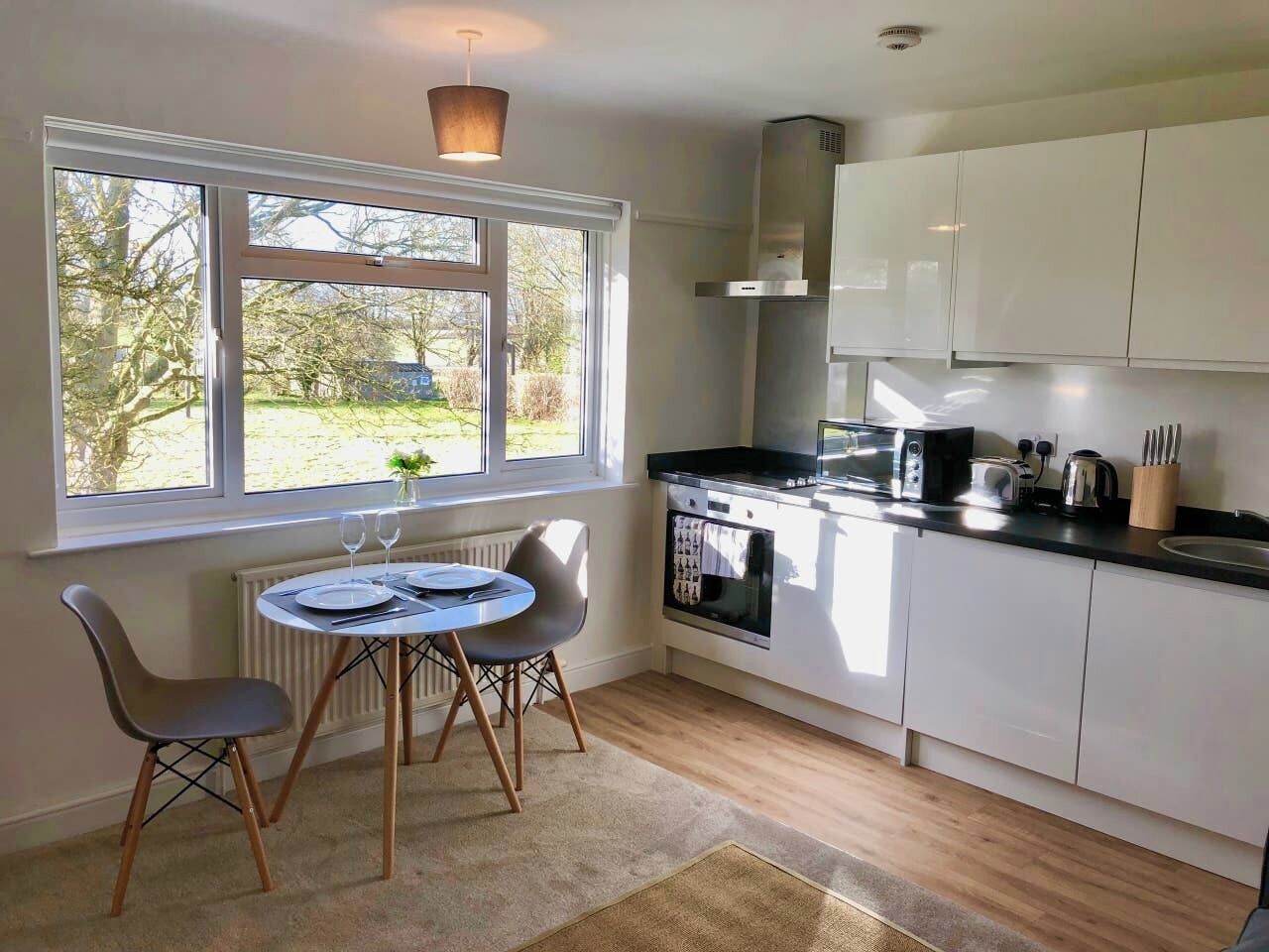 A compact kitchen with a dining area, a window with a view, and a built-in oven.