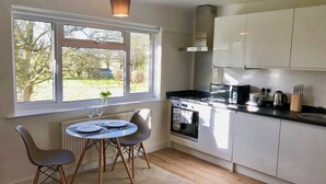 A compact kitchen with a dining area, a window with a view, and a built-in oven.