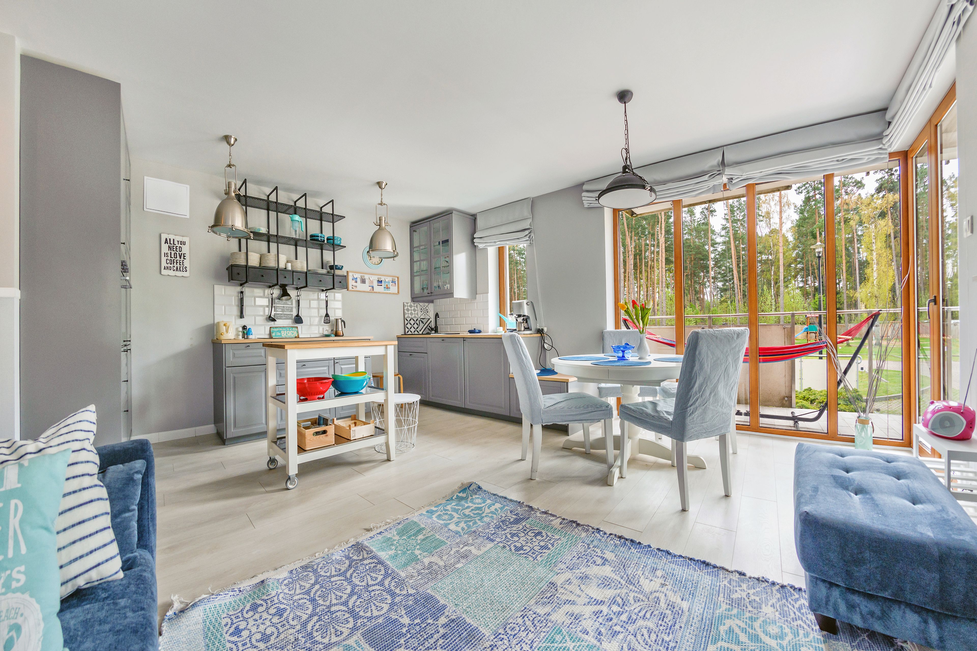 Een moderne keuken met een eethoek, grote ramen en uitzicht op het buitenland.