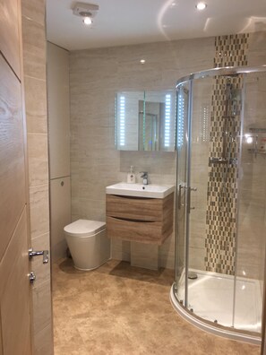 Shower, rainfall showerhead, hair dryer, towels -  New Forest Barton-on-Sea cliff top, ground floor, garden apartment. 'Bayside'. (Barton on Sea)