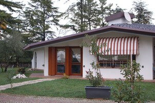 Una casa moderna con techo inclinado, un porche delantero y una antena parabólica.