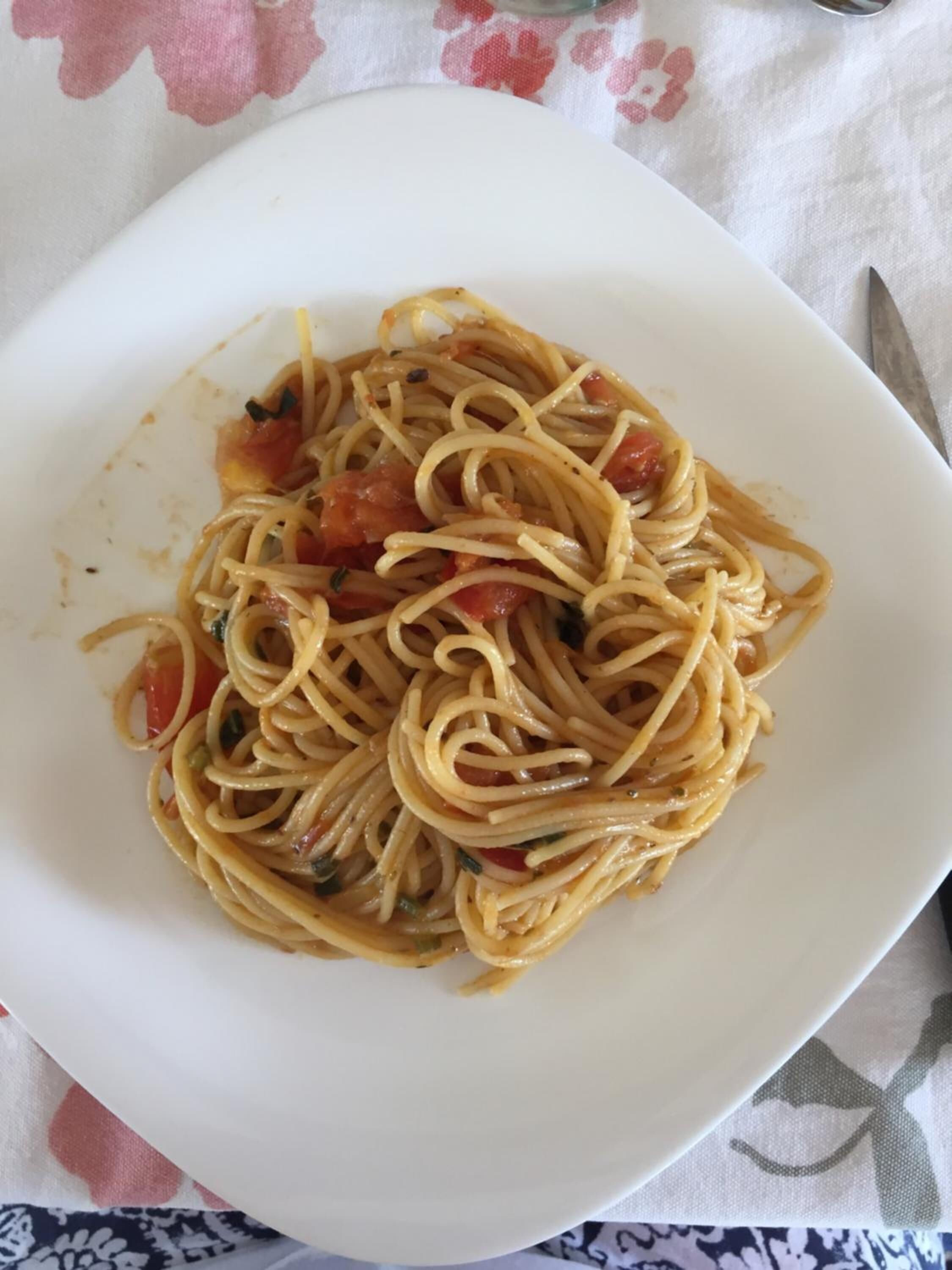 Une assiette de spaghettis à la sauce tomate et aux herbes.