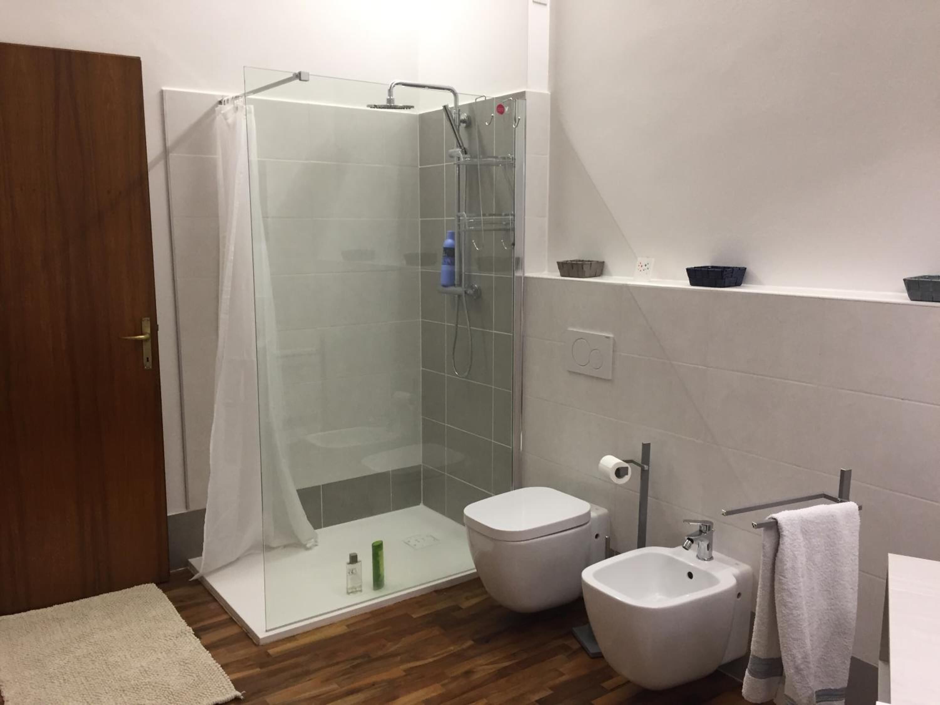 Une salle de bain moderne avec une douche à parois de verre, des toilettes, un bidet et un lavabo.