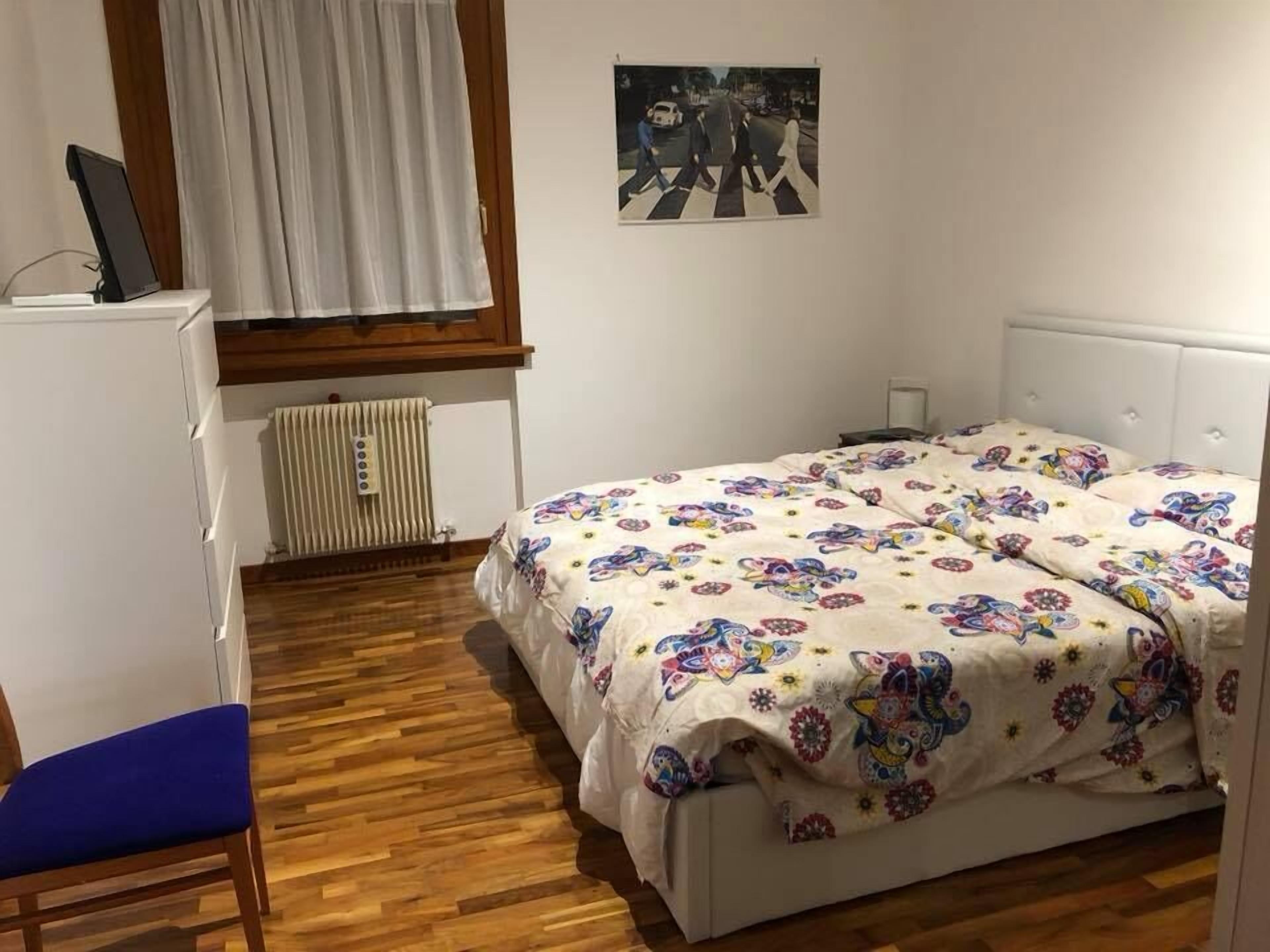 Un dormitorio con una cama, un escritorio y una silla.