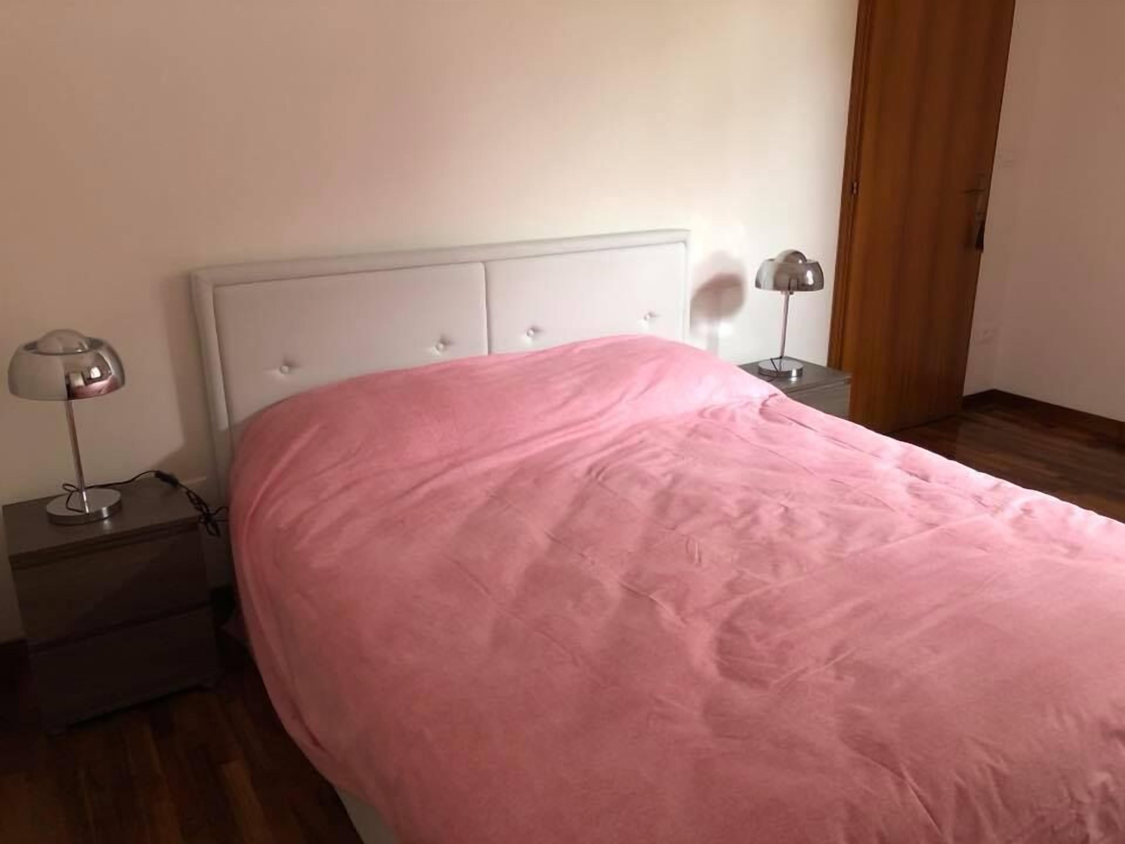 Ein Schlafzimmer mit einem Bett, zwei Nachttischen und einem Schrank.