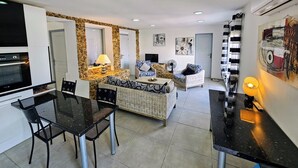 Um espaço compacto com cozinha compacta, área de refeições e espaço para sentar.