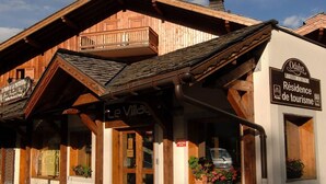 A wooden building with a sign for 'Odalys La Belle Montagne Residence de tourisme'. - 300m from ski slopes, swimming pool, balcony, tv, ski locker, 28m², Notre Dame de Bellecombe (Notre-Dame-de-Bellecombe)