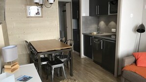 A modern kitchen with dark cabinets and a stainless steel sink. - Ski-in/ski-out & foot of the slopes, 4th floor, view mountain, balcony, tv, ski locker, 23m² (La Plagne)