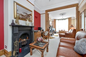 A living room with a fireplace, leather sofa, and wooden coffee table.