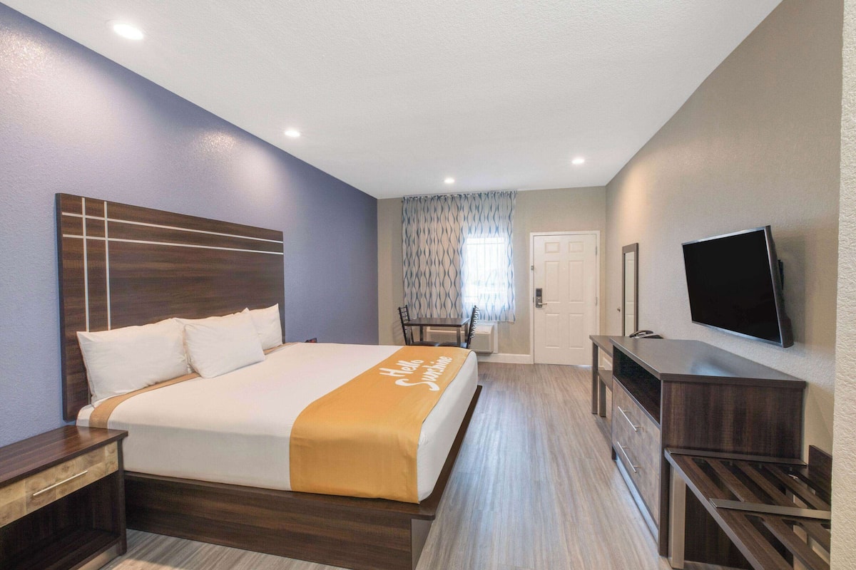 Escritorio, cortinas blackout y tabla de planchar con plancha