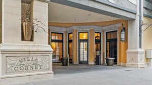 The entrance of Villa Coronet with a stone facade, large windows, and a sign above the entrance.