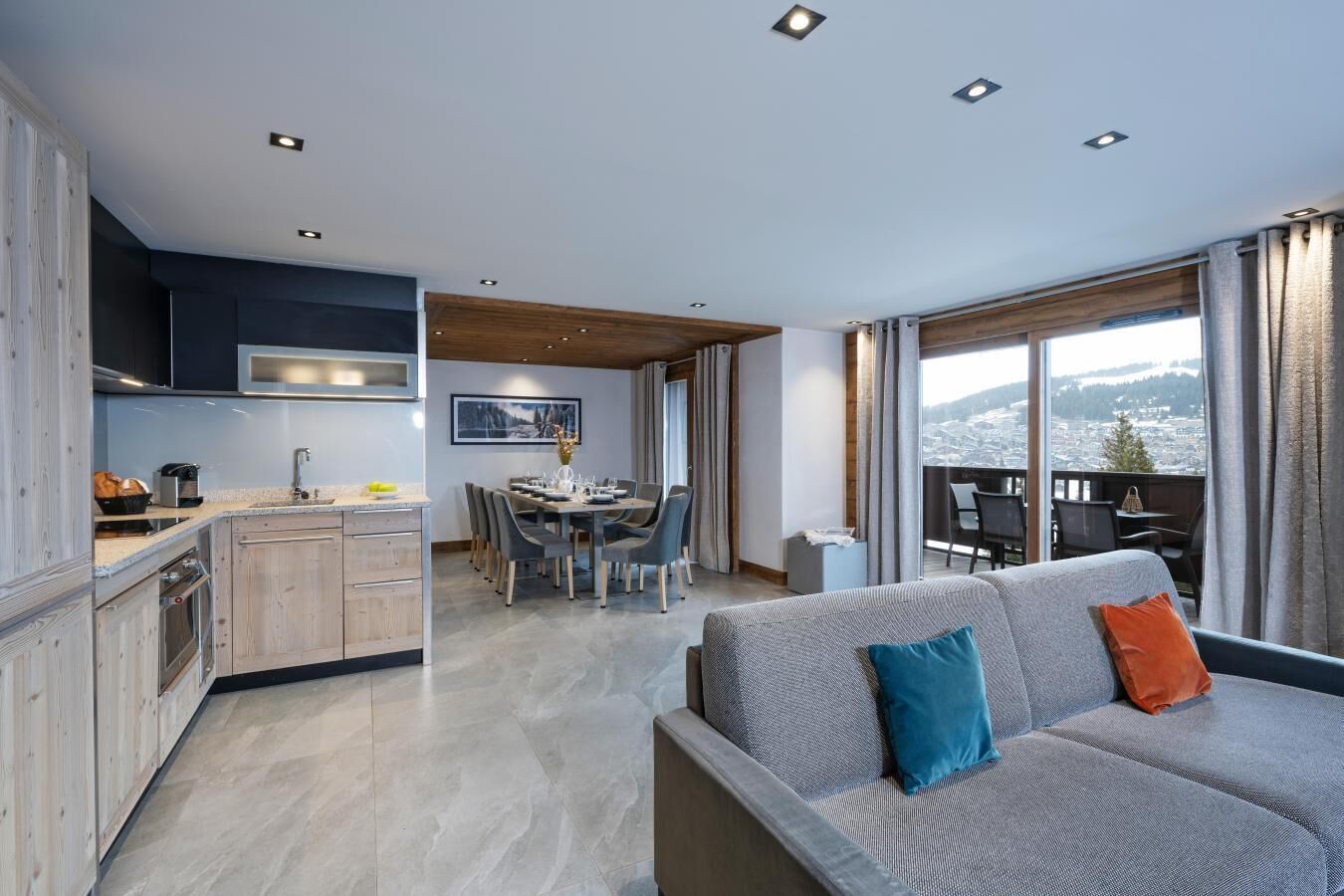 Un appartamento moderno con cucina, sala da pranzo e un balcone con vista sulla città.