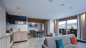 A modern apartment with a kitchen, dining area, and a balcony with a city view.